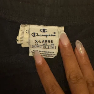 Svarta mjukisbyxor från Champion - Snygga svarta mjukisbyxor från Champion med en cool logga i rosa och vitt. Perfekta för en avslappnad stil. De har en bekväm passform och är gjorda i ett mjukt material.