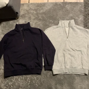 Två halvzip tröjor i marinblå och grå - Säljer två stilrena halvzip tröjor i marinblått och grått. Båda är i bra skick.  En för 175kr och båda för 350kr