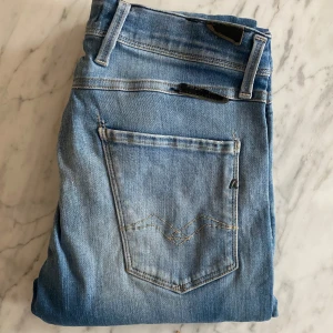 Replay anbass - Snygga blå jeans från Replay med en klassisk femficksdesign och ljusare tvätt. De har en knappgylf och är perfekta för en avslappnad stil. Märkeslogga syns på baksidan.