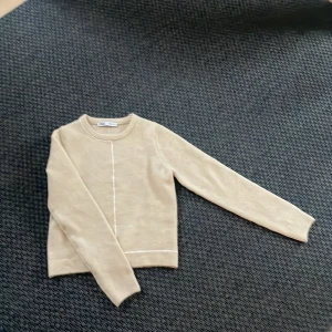 Beige tröja från Zara - Säljer en stilren beige tröja från Zara. Storlek S men passar även XS. Tröjan har långa ärmar och en enkel design med en subtil linje som detalj fram och baktill. Säljer då den aldrig kommit till användning, det är alltså aldrig använd men lappen är borta.💕 köparen står för frakt💕💕pris kan diskuteras