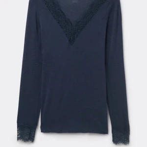 Intimissmi- Mörkblå långärmad topp med spetsdetaljer - Snygg mörkblå topp med långa ärmar och spetsdetaljer vid halsringning och ärmslut.  Köpte för ungefär ett halvår sen och har ett medelstort hål vid en av armarna.