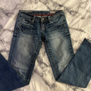 Blå bootcut jeans - Skit snygga jeans, dom är bootcut och Lågmidjade. Har suttit in ett snöre vid midjan som ni ser på bilden så du kan justera ifall dom skulle va lite stora. Strl: midjemått 39cm rakt över , innerbenslängden ca 77cm