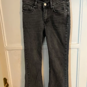 Grå jeans med bootcut - Snygga grå jeans med bootcut-stil och klassisk femficksdesign. De har en knapp och dragkedja framtill. Perfekta för en avslappnad look.