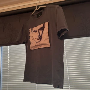 Grå t-shirt från Limitato  - Snygg grå t-shirt från Limitato med motiv på framsidan. Säljer då den är för liten för mig. Boxen följer med och tröjan har inga skador. Hör av er vid minsta fråga! Obs Priset kan diskuteras!