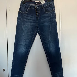 Blå jeans från FBSISTER  - Snygga blå jeans från New Yorker med knappgylf och klassisk femficksdesign. Jeansen har en modern tvätt och kontrastsömmar som ger en cool look. Perfekta för en avslappnad stil.
