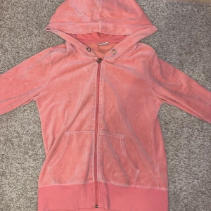 Rosa hoodie med dragkedja - Säljer en mysig rosa hoodie med dragkedja och huva. Den har långa ärmar och en praktisk ficka framtill. Perfekt för en avslappnad stil.