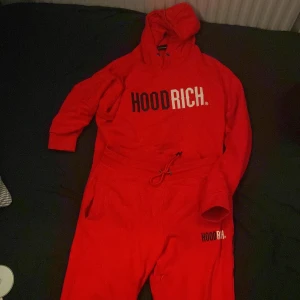 Röd hoodie från Hoodrich+ byxor  - Säljer en röd hoodie från Hoodrich med tryck på bröstet. Röda byxor med ett litet tryck på höger sidan
