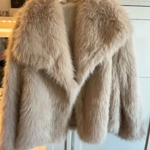 Beige pälsjacka - Säljer en supermjuk och fluffig beige pälsjacka. Perfekt för att hålla sig varm och stilren under kyliga dagar. Jackan har en klassisk design med långa ärmar och en generös krage.