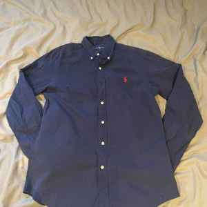 Mörkblå Ralph Lauren skjorta - En stilig Ralph lauren skjorta i storlek M. Mycket bra skick o inga tecken på användning. Nypris ligger på 1795kr