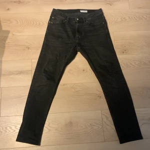 Tiger Of Sweden Jeans - Snygga grå jeansbyxor i modellen Pistolero. De har en klassisk femficksdesign med dragkedja och knapp framtill. Perfekta för en stilren look.