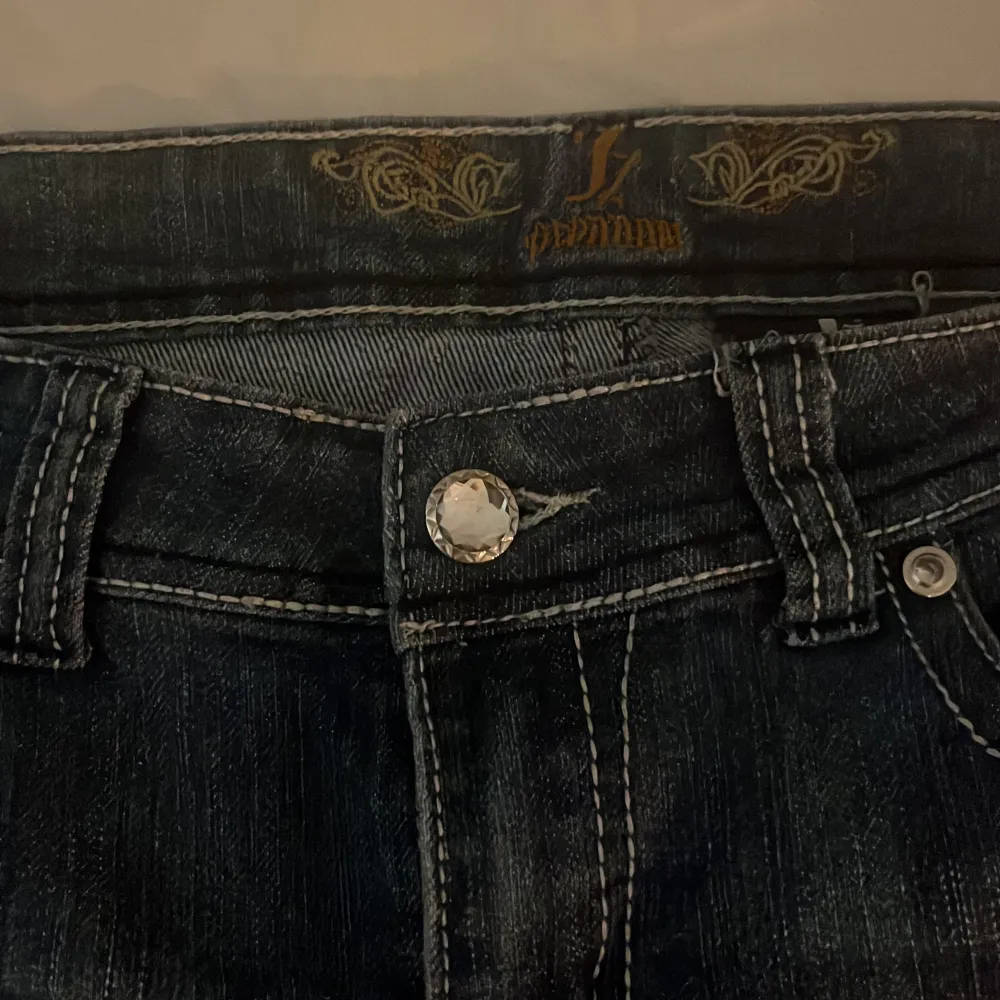 Snygga mörkblå jeans med coola detaljer på fikorna där back och jätte snygga knappar. Dom är köpta  i London, säljer dom pga att jag tycker dom är lite för korta och inte riktigt min stil, är 165 cm lång så dom passar nog dig som är några cm kortare . Jeans & Byxor.