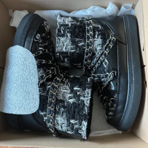 Svarta boots från Inuikii - Säljer ett par snygga svarta boots från Inuikii i mycket bra skick. De har en cool kombination av skinn och textil med ett unikt mönster. Insidan är fodrad för extra värme och komfort. Perfekta för höst och vinter! 🖤