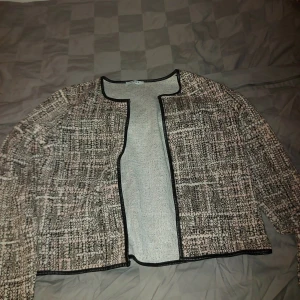 Rutig kavaj från Pieces - Säljer en snygg rutig kavaj från Pieces i storlek M. Den har en klassisk svart och vit färgkombination med långa ärmar och en öppen design utan knappar. Perfekt för både vardag och festliga tillfällen. Passar bra till höst och vår!