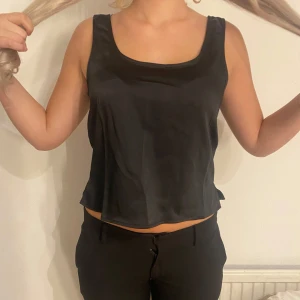 Svart satinlinne från Bik Bok - Snyggt svart satinlinne från Bik Bok i storlek XS. Linnet har en djup rundad urringning både fram och bak.. Perfekt för festliga tillfällen eller en utekväll. Endast testad med prislapp kvar! kom privat för mer info/bilder!