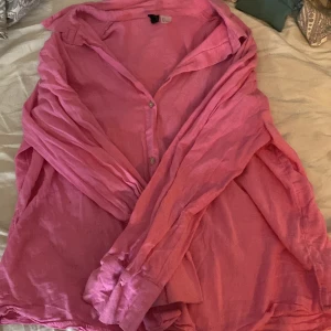 Rosa skjorta från Divided - Säljer en snygg rosa skjorta från Divided i storlek L. Skjortan har en avslappnad stil med långa ärmar och knappar framtill. Perfekt för både vardag och festliga tillfällen. Den är i mycket bra skick och redo för en ny ägare! 💖