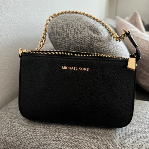 Michael Kors Väska - Liten stilren väska i svart med guld kedja och guld detaljer från Michael Kors. 