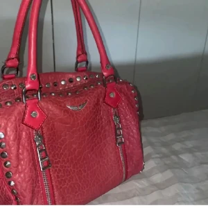 Zadig väska - Unik röd zadig väska med nitar. Köpt second hand så lite slit men annars jättebra skick. Knappt använd. Kan sälja billigare vid snabb affär ❤️❤️