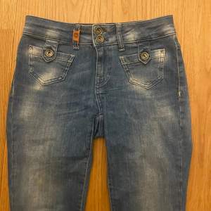 Säljer ett par snygga blå jeans från Pulz Jeans. De har en bootcut-stil och är Lågmidjade med coola detaljer som knappar på fickorna. Priset kan diskuteras.