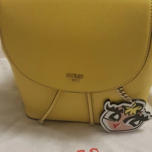 Väskor  - Jag säljer min fina väska Guess rygväska, mycket bra skick använd 2 gånger  inga skador ej smutsig, men stått i garderoben ett bra tag,,,Hör av dig vid intresse,,,,