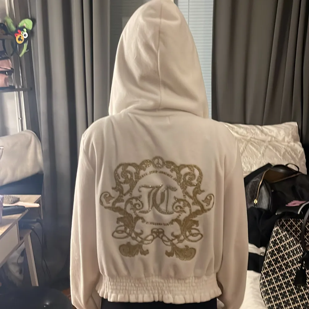 Säljer en superfin vit hoodie från Juicy Couture i mycket bra skick. Den har en snygg gulddetalj på dragkedjan och ett stort, glittrigt emblem på ryggen. Perfekt för både vardag och festliga tillfällen. Det står storlek M men skulle säga att det är storlek XS nytt skick.. Tröjor & Koftor.