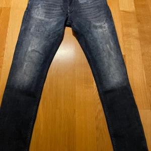 Mörkblå jeans med skön färg och feta slitningar  - Säljer ett par mörkblå jeans i bra skick. De har en snygg tvättad look med feta slitningar🤩. Jeansen är i storlek 34/34 och använda Max 5 gånger. Perfekta för både höst och vinter🍁❄️. Vid fler frågor / bilder är det bara att kontakta!😁