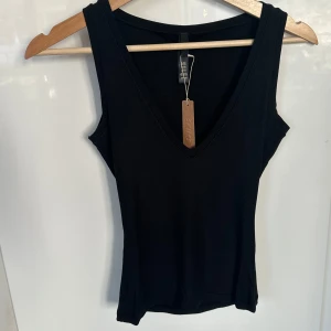 Skims linne - Säljer helt nytt linne från Skims. Lappen sitter på och ordinarie påse finns kvar🥰 modellen heter Deep Plunge Tank och är i färgen Onyx. Ordinarie pris 602 kr