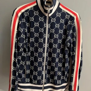 JACQUARD COTTON JACKET - Säljer en Gucci jacka köpt I Gucci Stockholm . Jackan är mörkblå med vita detaljer och har röda och vita ränder längs ärmarna. Storlek S. Ej använd mycket. Nypris 15 750kr.OBS/Äkta finns kvitto! Kan mötas i Stockholm!