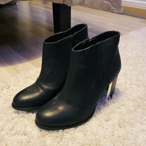 Svarta boots med klack - Snygga svarta boots i skinn med dragkedja på sidan.Stl 39!  De har en stabil klack som ger lite extra höjd och stil. Perfekta för både vardag och fest! 🖤
