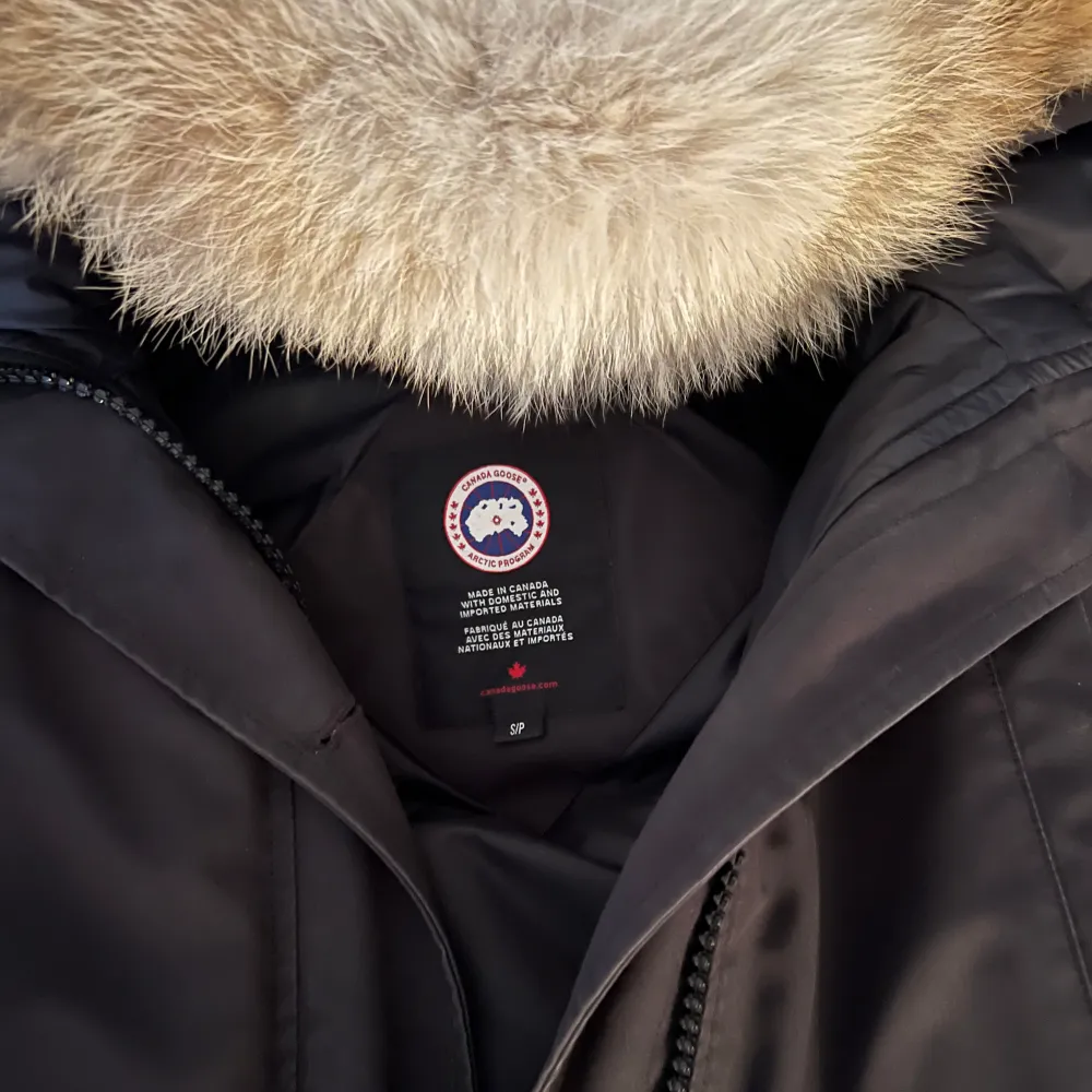 Säljer en svart vinterjacka från Canada Goose i mycket bra skick. Jag köpte den för typ 1 månad sen men nu ska jag köpa en annan jacka så måste sälja denna:) Jackan har en stor huva med päls och stängs med både dragkedja och knappar. Pälsen kan man ta av och på. . Jackor.