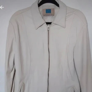 Beige jacka från Vera Pelle - Säljer en stilren beige jacka från Vera Pelle. Den har en dragkedja framtill och en klassisk krage. Perfekt för höst och vår, med en normal passform som funkar till de flesta outfits. Jackan är i mycket bra skick och passar både till vardags och lite finare tillfällen.