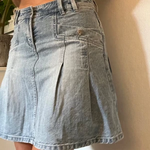 Ljusblå jeanskjol - Kjol med fina detaljer, nästan knälång. Passar mig med S/M. Frakt tillkommer på 58kr 🫶🏻