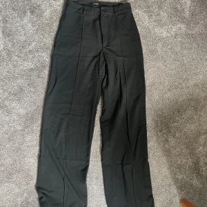 Svarta kostymbyxor - Säljer ett par stilrena svarta kostymbyxor. De är högmidjade och har en rak passform som ger en klassisk look. Perfekta för både kontoret och festligare tillfällen.