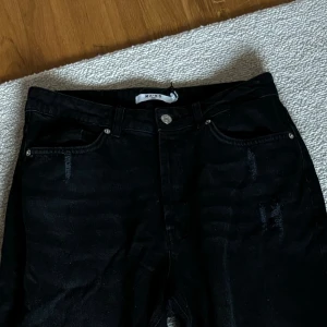 NA-KD Jeans - Jeans storlek 38 från NA-KD Hål på knäna samt slitningar både bak och fram. Aldrig använda