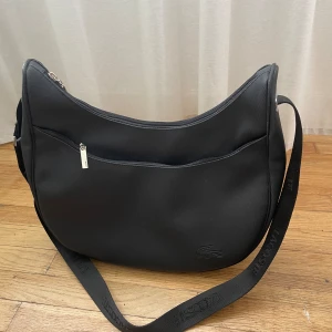 Väska - Crossbody väska frå lacroste, justerbara axelband!  Nyskick 