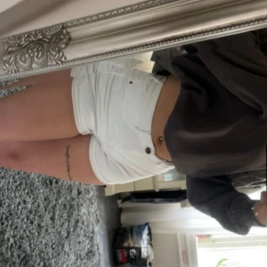 Vita jeansshorts - Säljer ett par vita jeansshorts i nyskick. De är i mid waist och har en knapp och dragkedja framtill. Perfekta för sommaren och passar till både vardag och fest. De har en tight passform och är superbekväma att ha på sig. 🩳✨ Som man ser på sista bilden är det lite slitage fram på byxorna (mellan benen), inget som jag tycker syns när man har på sig dom. Kan finnas andra små defekter men det är inget märkvärdigt då jag inte kan se det med blotta ögat.