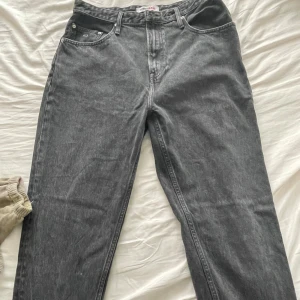 Grå jeans från Tommy Jeans - Säljer ett par snygga grå jeans från Tommy Jeans. De har en klassisk femficksdesign och en bekväm passform. Perfekta för både vardag och fest! 🖤står strl 34/32 men passar L 