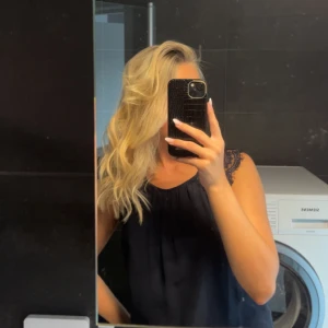 Mörkblå ärmlös topp - Säljer en snygg mörkblå ärmlös topp från Vero Moda med spetsdetaljer vid axlarna. Perfekt för både vardag och fest 🤍