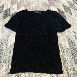 T-shirt  - En svart T-shirt med mjukt material, från Bik Bok, storlek XS, använd ett fåtal gånger 