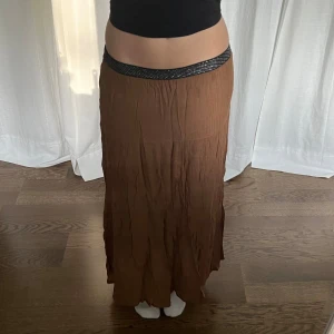 Långkjol - Brun långkjol från Luxzuz. Midjemått: 66-90 cm, 33-45 cm rakt övee. Längd: 95 cm 🤎