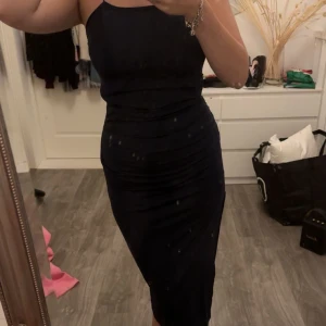 Klänning - Fin mörkblå klänning med knytning i ryggen. 