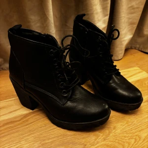 Svarta boots med klack och snörning - Snygga svarta boots i skinn från Vox Shoes i storlek 37. De har en rejäl klack och snörning framtill samt en praktisk dragkedja på sidan. Perfekta för höst och vinter när du vill ha både stil och komfort. Passar lika bra till vardags som till fest!