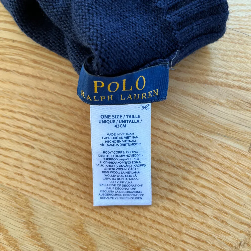 Snygg mörkblå mössa från Polo Ralph Lauren med röd broderad logga framtill. Den är stickad och har en ribbad kant som ger en skön passform. Perfekt för kyliga dagar och en stilren look. 🖤. Övrigt.