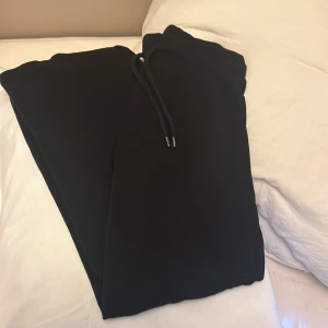 Svarta mjukisbyxor från H&M - Säljer ett par svarta mjukisbyxor från H&M i storlek XS. De är superbekväma och perfekta för en chill dag hemma eller en snabb tur till affären. Byxorna har en elastisk midja med snörning för bästa passform. Perfekta för höst och vinter!
