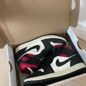 Säljer ett par snygga Nike Air Jordans i klassiska färgerna svart, vitt och rött. Skorna har en cool design med snörning och är i mycket bra skick. Perfekta för både vardag och fest! 🏀