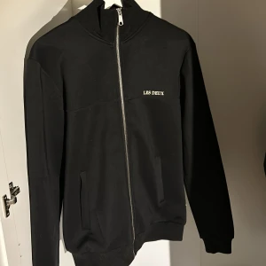 Svart jacka från Les Deux - Säljer en stilren svart tröja/jacka från Les Deux i storlek S men känns som m. Jackan har en dragkedja framtill och är långärmad. Perfekt för höst och vår, med en enkel och klassisk design som passar till det mesta. Den är i 10/10 skick då den endast är använd under 5 gånger! Säljer endast pågrund av att jag fick en likadan i present.