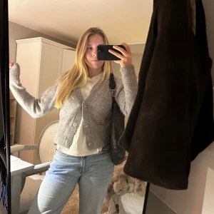 Grå kofta med knappar - Säljer min mysiga grå kofta i bra skick med knappar framtill. Perfekt för höst och vinter, och den har en normal passform. Koftan är långärmad och och den innehåller alpackaull💗Den är o väldigt bra skick 