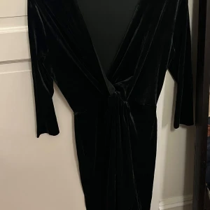 Grön  kjole i sammet från Zara Basic - Elegant grøn kjole i mjuk sammet från Zara Basic. Den har en v-ringad design och trekvartsärmar, perfekt för en festlig kväll. Storlek M, lite liten över höfterna