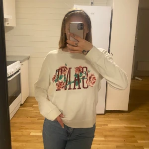 Vit sweatshirt från GANT - Säljer en snygg vit sweatshirt från GANT med ett coolt blommönster och text på framsidan. Tröjan är i bra skick och perfekt för både vardag och chill. Den har långa ärmar och en skön passform. Perfekt för höst och vår!
