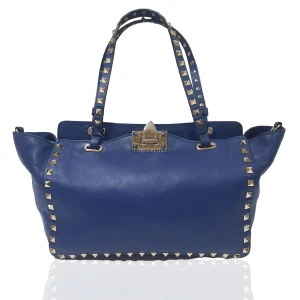 Valentino väska - Säljer nu denna superfina Valentino Rockstud Tote väska i marinblå. Det är i väldigt gott skick, alla bitar är kvar och har alla äkthetsbevis. Storlek medium