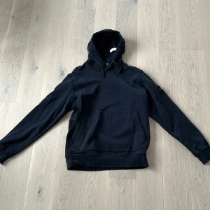 Stone island hoodie - Säljer min stone island hoodie har inte använt den något och inget är fel typ använd 3 ggr sen har den bara hängt i gadroben och blivit dags att rensa lite köpt på nk o Stockholm för 3 månader sedan . Storleken är xl men själv har jag m och de passar